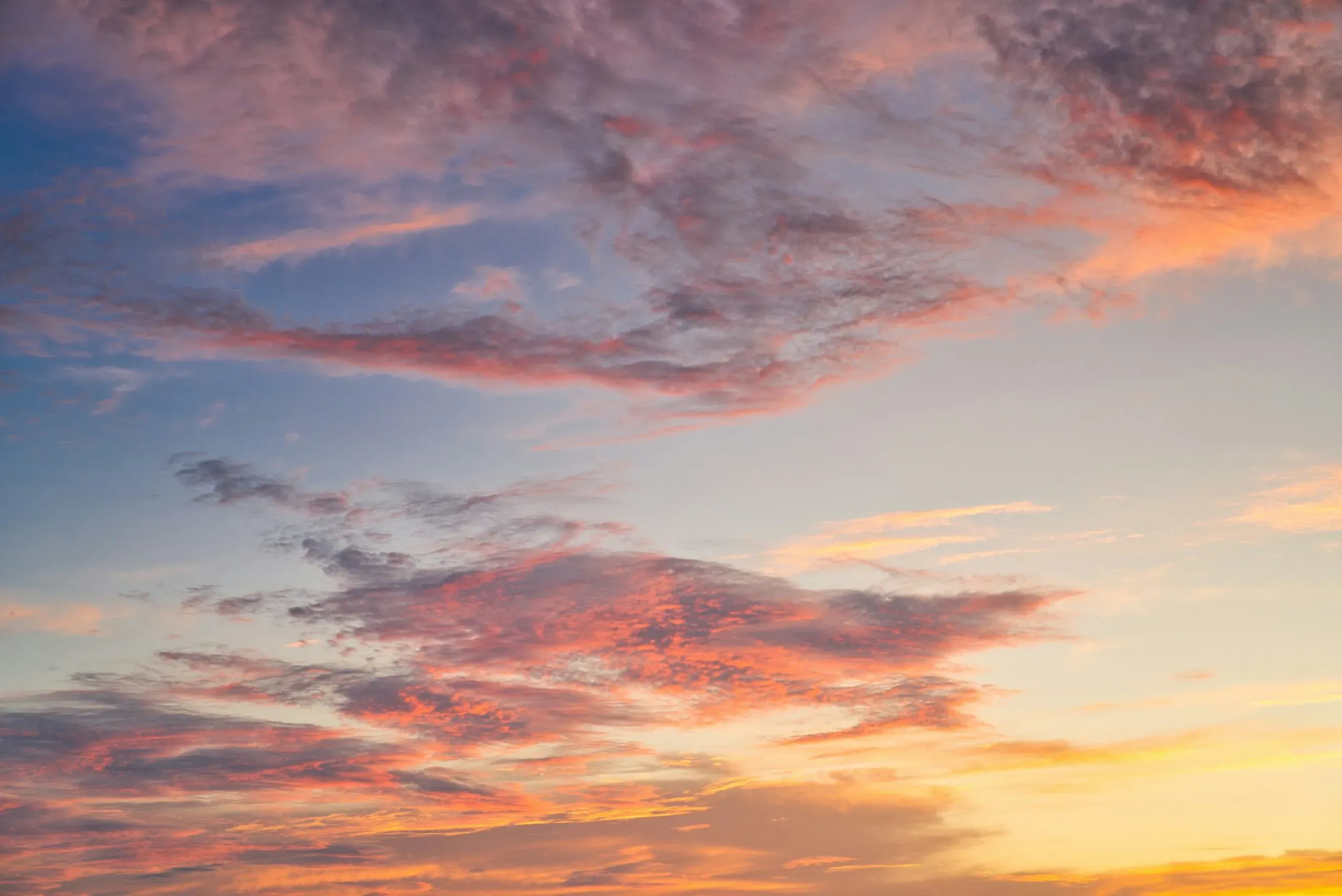 Ciel crépusculaire nuancé de teintes roses et orangées lors du couchant