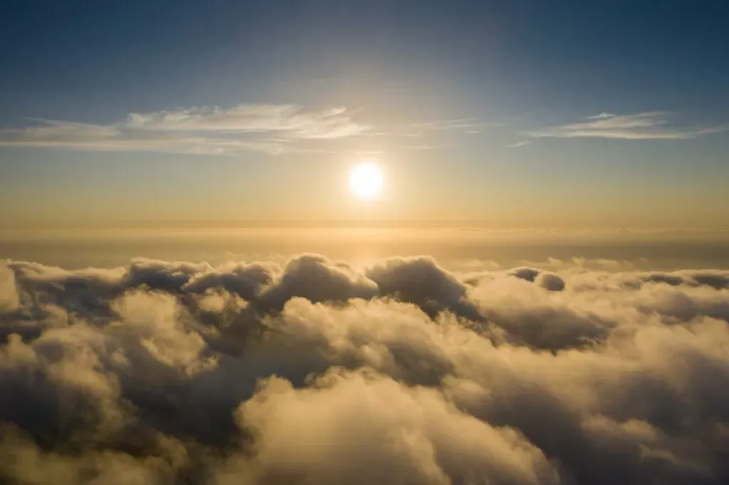 Vue aérienne d'un ciel ensoleillé au-dessus d'une mer de nuages dorés au coucher du soleil